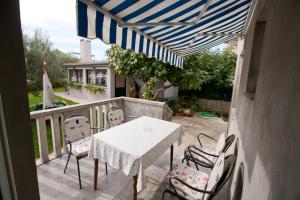 eine Terrasse mit Tisch und Stühlen auf einem Balkon in der Unterkunft G&G apartments in Zadar