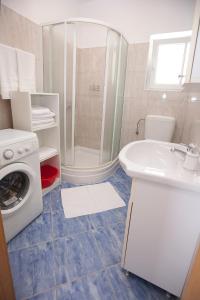 ein Badezimmer mit einem Waschbecken und einer Waschmaschine in der Unterkunft G&G apartments in Zadar + 23 Fotos