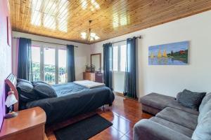 a living room with a bed and a couch at Peaceful retreat near Levadas in Ribeira do Raposo