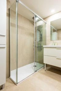 een glazen douche in een badkamer met een wastafel bij Prudencio 36 in Zaragoza +32 foto's