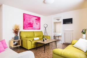 een woonkamer met een gele bank en een tafel bij Prudencio 36 in Zaragoza
