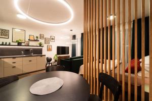 a living room with a table and a bedroom at Green Garden Sauna Apartment in Brno