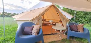 a tent with two chairs and a table in front at Waldkiez Tiefensee in Tiefensee