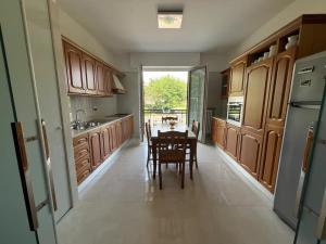 a kitchen with wooden cabinets and a table with chairs at Lenuare Luxury Apartment in Desenzano del Garda