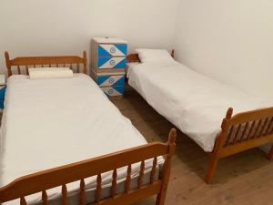 two twin beds in a room with a dresser at Dušanov konak in Vrbas