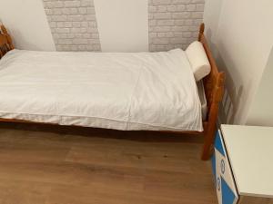 a small bed in a room with a white bedspread at Dušanov konak in Vrbas +4 photos
