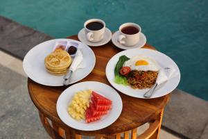 a table with plates of food and two cups of coffee at MT Penida Bungalow in Nusa Penida +17 photos