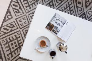 ケープタウンにあるAvenue One Apartmentsのコーヒーと雑誌が置かれたテーブル