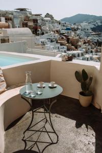 uma mesa numa varanda com vista para a cidade em Spitia Santorini Villa Collection em Oia