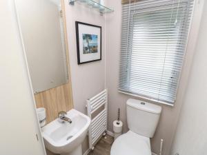 カウズにあるSerenityの白いトイレと洗面台のあるバスルーム +15枚の写真