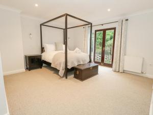 1 dormitorio con cama grande con dosel y mesa en Sunningdale Rise, en Weymouth