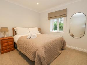 a bedroom with a large bed and a mirror at Sunningdale Rise in Weymouth