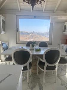 a dining room with a table and chairs and a window at Immaculate apartment in Umm Uthainah