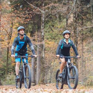 two people riding bikes on a trail in the woods at Bosc del Meneghì in Ledro