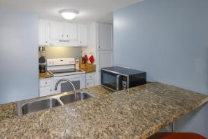 a kitchen with a sink and a microwave at Sugar Beach 353 in Gulf Shores