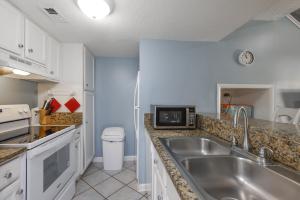a kitchen with a sink and a microwave at Sugar Beach 353 in Gulf Shores