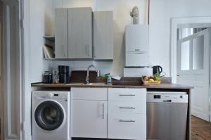 une cuisine avec un évier et une machine à laver dans l'établissement Courtyard Apartment (LIALI), à Berlin 10 autres photos