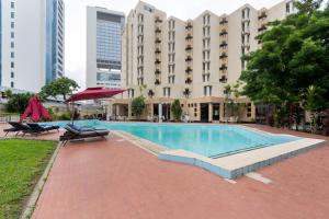 a swimming pool with two chairs and a building at Sigma Base Apartments in Lagos