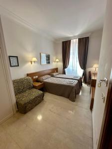 a hotel room with a bed and a chair at Hotel Principe Di Piemonte in Rome +85 photos