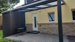 a black pergola on the side of a house at Apartment im Hinterhof in Bersenbrück