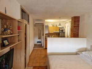 a bedroom with a white bed and a kitchen at Studio Apartment Riva in Sumartin