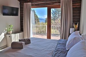 a bedroom with a large bed and a sliding glass door at Casa VanTitter in San Carlos de Bariloche