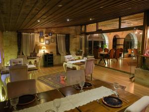 a dining room with a table and chairs and a living room at Sakli Konak Cappadocia Hotel&Restaurant in Uçhisar