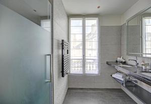 a bathroom with a shower and a sink and a mirror at Chalgrin Boutique Hotel in Paris +43 photos