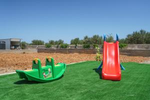 two childrens play equipment on a artificial grass field at New Villa Luna with Private Pool, Ping Pong and BBQ 1km from the beach in Sfakaki