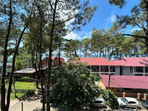 a house with a pink roof and cars parked in front at Decom Riviera in Shekhvetili