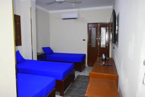 库塞尔Amoaj hotel فندق امواج的一间设有两张蓝色的床和一张桌子的房间