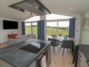 Una cocina y una sala de estar con mesa y sillas. en Cove Lodge, en Ilfracombe