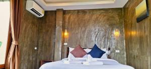 a bedroom with a large bed with pillows at Namu Hotel in Pai