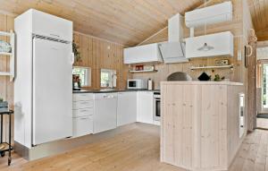 a kitchen with white appliances and a wooden ceiling at 2 Bedroom Cozy Home In Højslev in Højslev