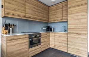 a kitchen with wooden cabinets and a stove top oven at Westergeest Luxe in Uitgeest