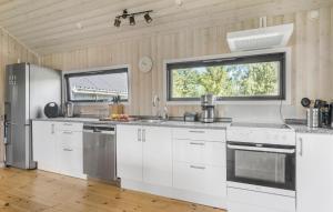 ジルレジェにあるAwesome Home In Gilleleje With Wifiの白いキャビネットとステンレス製の電化製品を備えたキッチン +10枚の写真