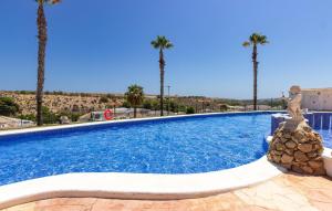 a large swimming pool with palm trees in the background at Stunning Home In San Fulgencio in San Fulgencio +17 photos