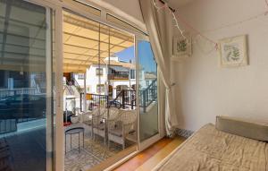 a room with a balcony with a bed and a sliding glass door at Stunning Home In San Fulgencio in San Fulgencio