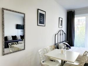 tavolo e sedie bianchi in una stanza con specchio di 2026 Apartament Golden Treasure V a Władysławowo