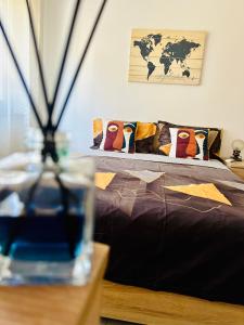 a bed with pillows and a vase on a table at Snug apartament in Iaşi