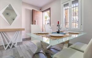 a dining room with a glass table and white chairs at Two-Bedroom Stunning Home In El Gastor in El Gastor