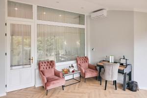 a room with a table and two chairs and a desk at Lacul Verde Resort in Ploieşti
