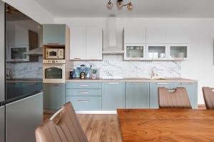 Una cocina con gabinetes azules y una mesa de madera. en Villa Agape - heated pool, en Raštević
