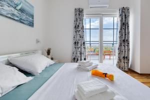 Un dormitorio con una cama grande con toallas. en Villa Agape - heated pool, en Raštević 51 fotos más