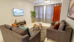 a living room with two couches and a table at Lekki FootPrint, Lekki Phase1 in Lekki
