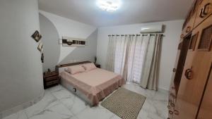 a small bedroom with a bed and a window at APTO DUPLEX 3 Dorm em APARECIDA 600 m da basilica in Aparecida