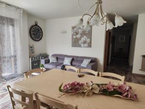 a dining room table with a flower arrangement on it at A Casa di Kate in Borno