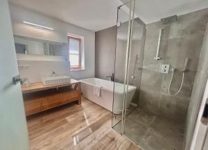 施利尔塞Ferienhaus "Seeblick" direkt am Schliersee的带淋浴、浴缸和水槽的浴室