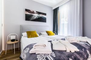 Dos camas en un dormitorio con toallas. en Apartament Ski Arena Spa, en Białka Tatrzanska