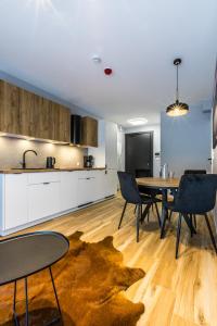 Una cocina y un comedor con mesa y sillas. en Apartament Ski Arena Spa, en Białka Tatrzanska